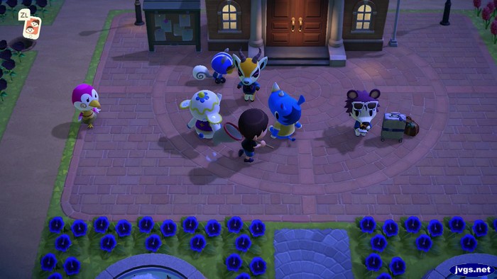 Midge, Agent S, Lopez, Tia, Jeff, Hornsby, and Label crowd the plaza outside of town hall.