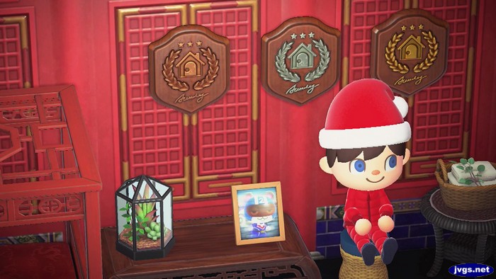 Jeff sits next to Agent S's photo in Animal Crossing: New Horizons.