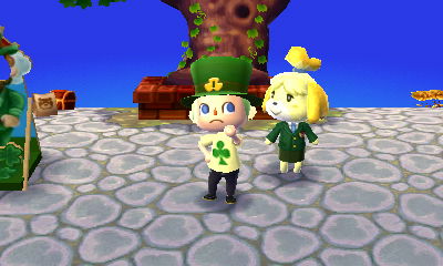 Jeff, wearing a shamrock hat, stands next to Isabelle, who is dressed in green, on Shamrock Day.